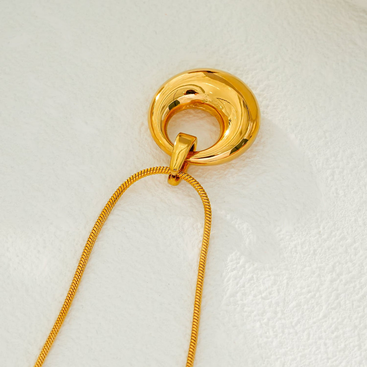 ALBASIMI : Chaîne peau de serpent avec fermoir serti d'oxydes de zirconium (CZ) et pendentif cercle asymétrique.