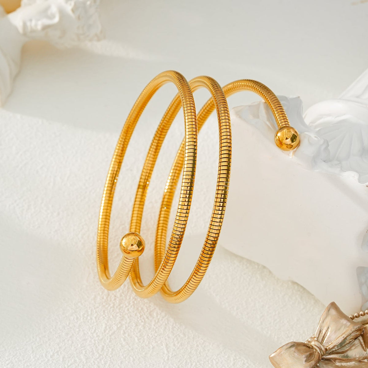 BASHEE : Bracelet triple en or avec lignes de surface et perles décoratives.