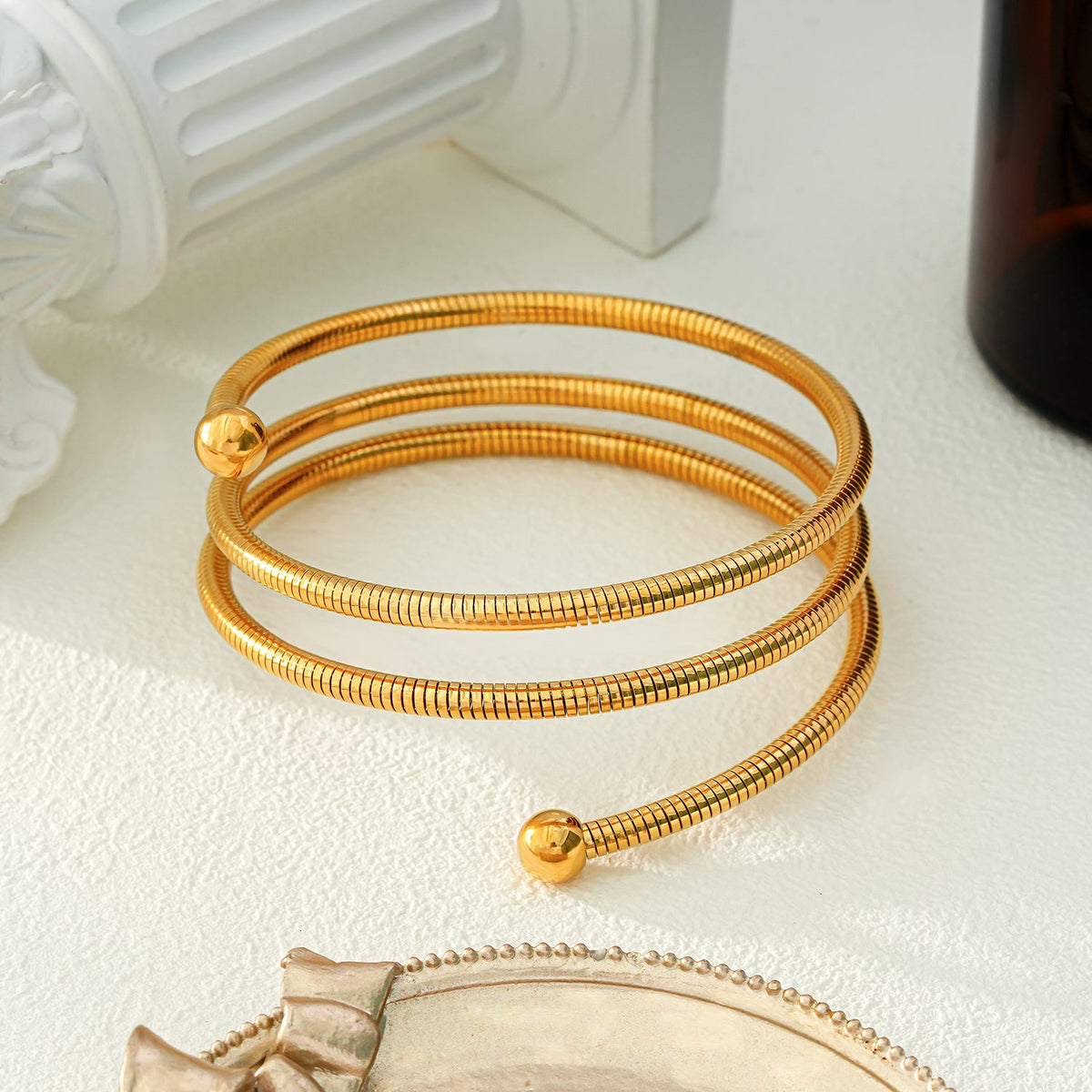 BASHEE : Bracelet triple en or avec lignes de surface et perles décoratives.
