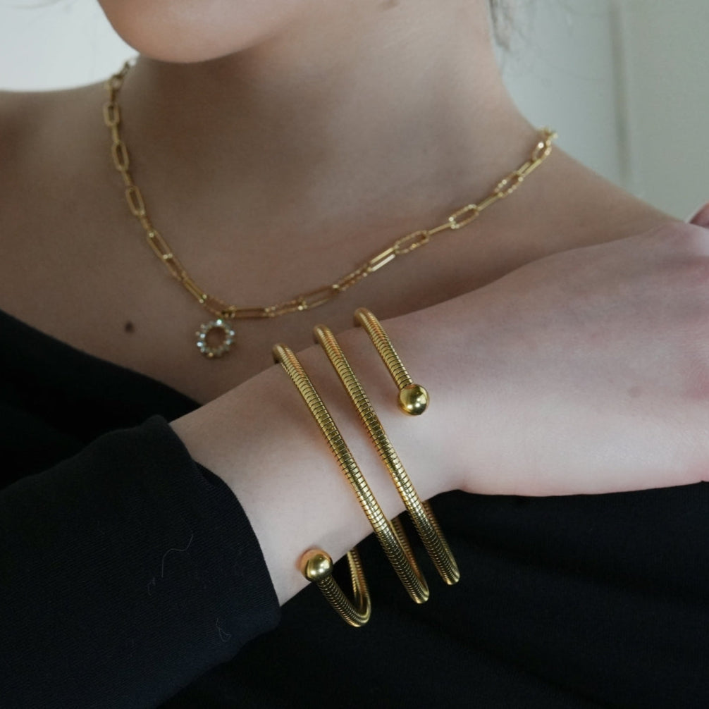 BASHEE : Bracelet triple en or avec lignes de surface et perles décoratives.