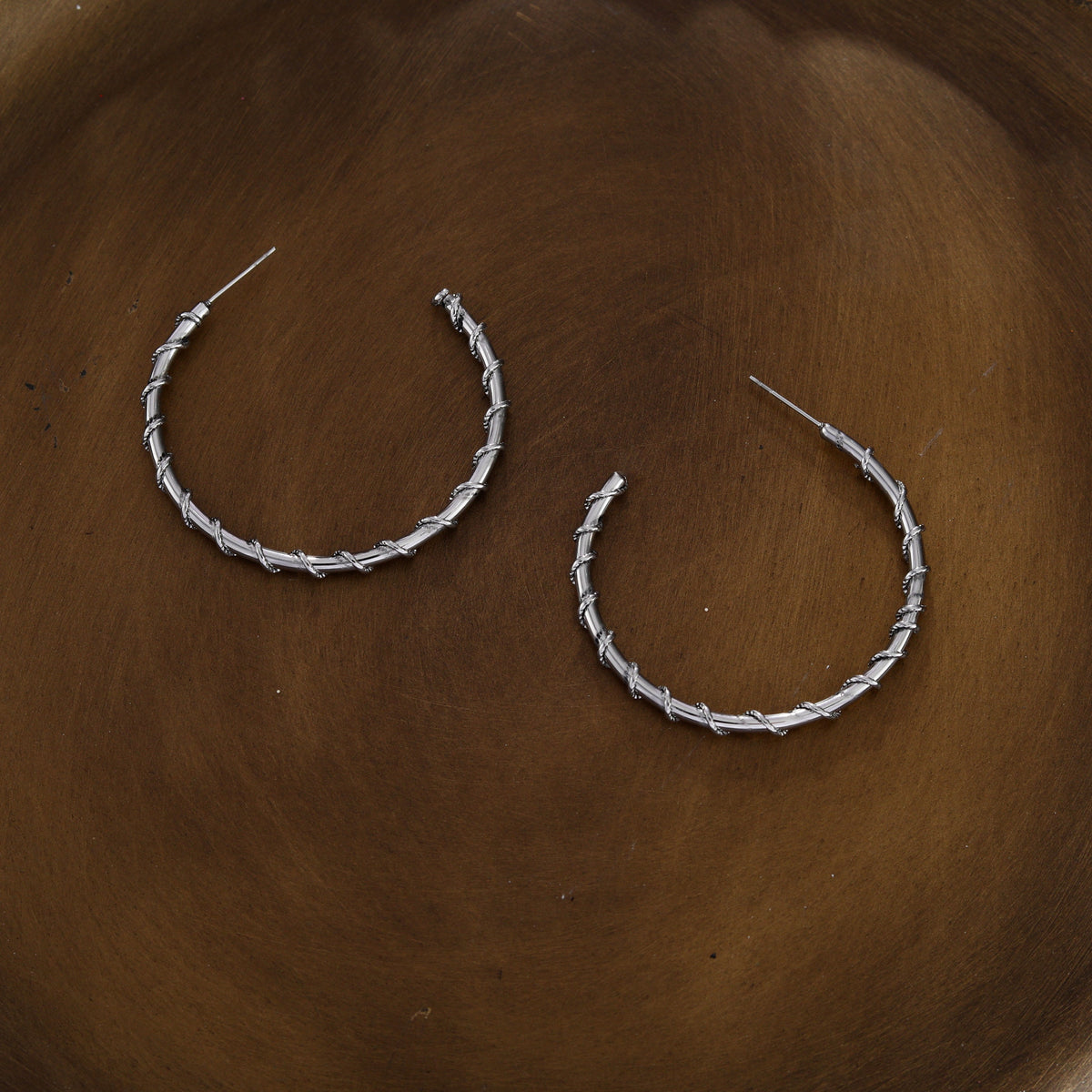 Boucles d'oreilles créoles ELNA argentées avec une torsade décorative
