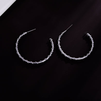 Boucles d'oreilles créoles ELNA argentées avec une torsade décorative