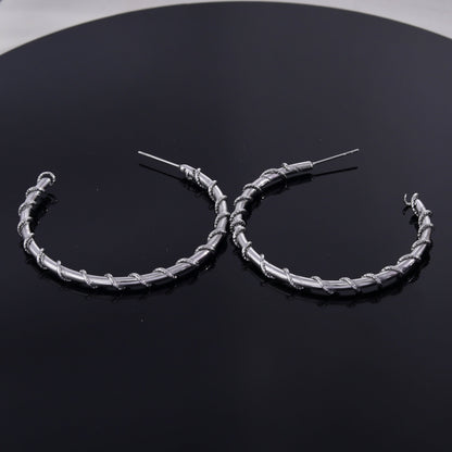 Boucles d'oreilles créoles ELNA argentées avec une torsade décorative