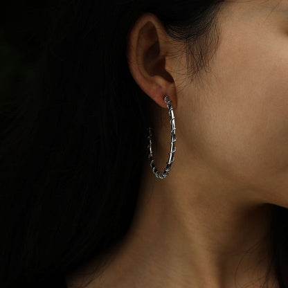 Boucles d'oreilles créoles ELNA argentées avec une torsade décorative