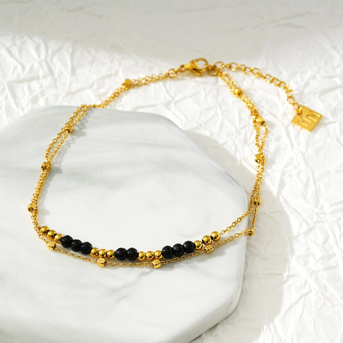 HILDA LG : Bracelet de cheville perles carrées et perles rondes deux-en-un noir et or.