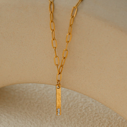 Style KORATIA : Collier Minimaliste avec Chaîne Trombone et Pendentif Barre Ornée de Zirconium Doré