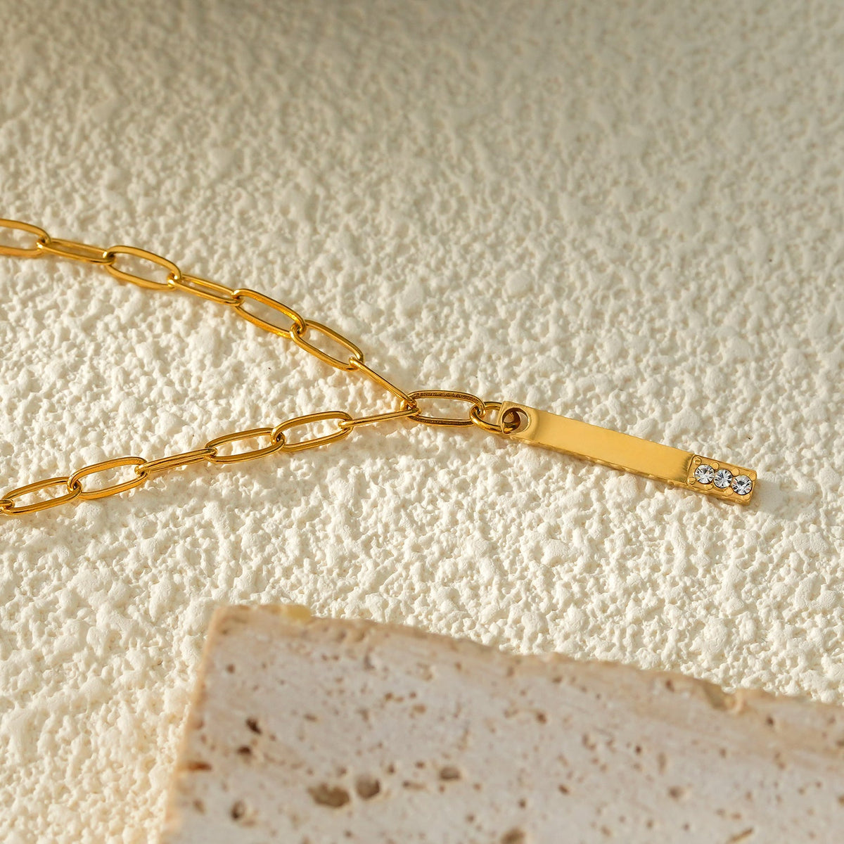 Style KORATIA : Collier Minimaliste avec Chaîne Trombone et Pendentif Barre Ornée de Zirconium Doré