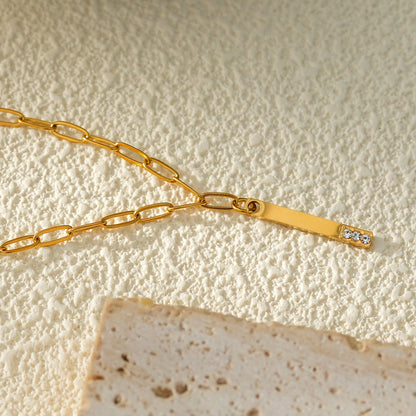 Style KORATIA : Collier Minimaliste avec Chaîne Trombone et Pendentif Barre Ornée de Zirconium Doré