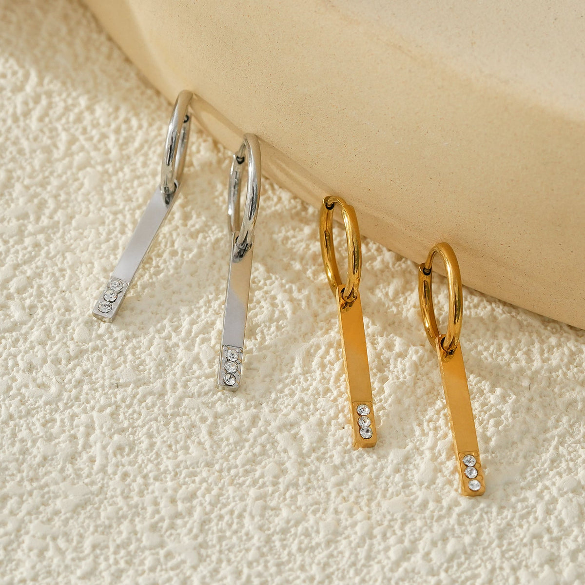 Style MAYLA : Créoles dorées au charme minimaliste, rehaussées d'un trio de zircons.