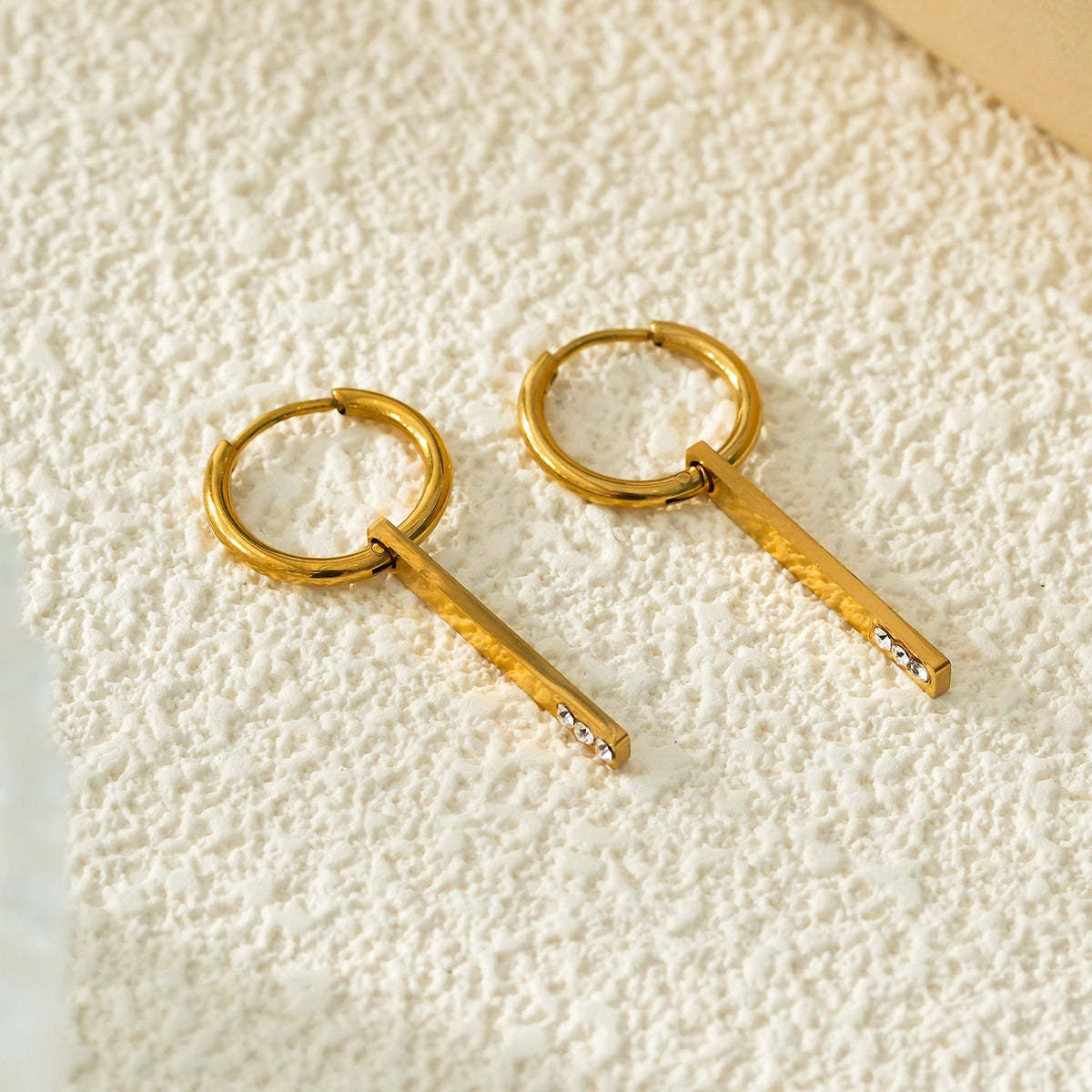 Style MAYLA : Créoles dorées au charme minimaliste, rehaussées d'un trio de zircons.