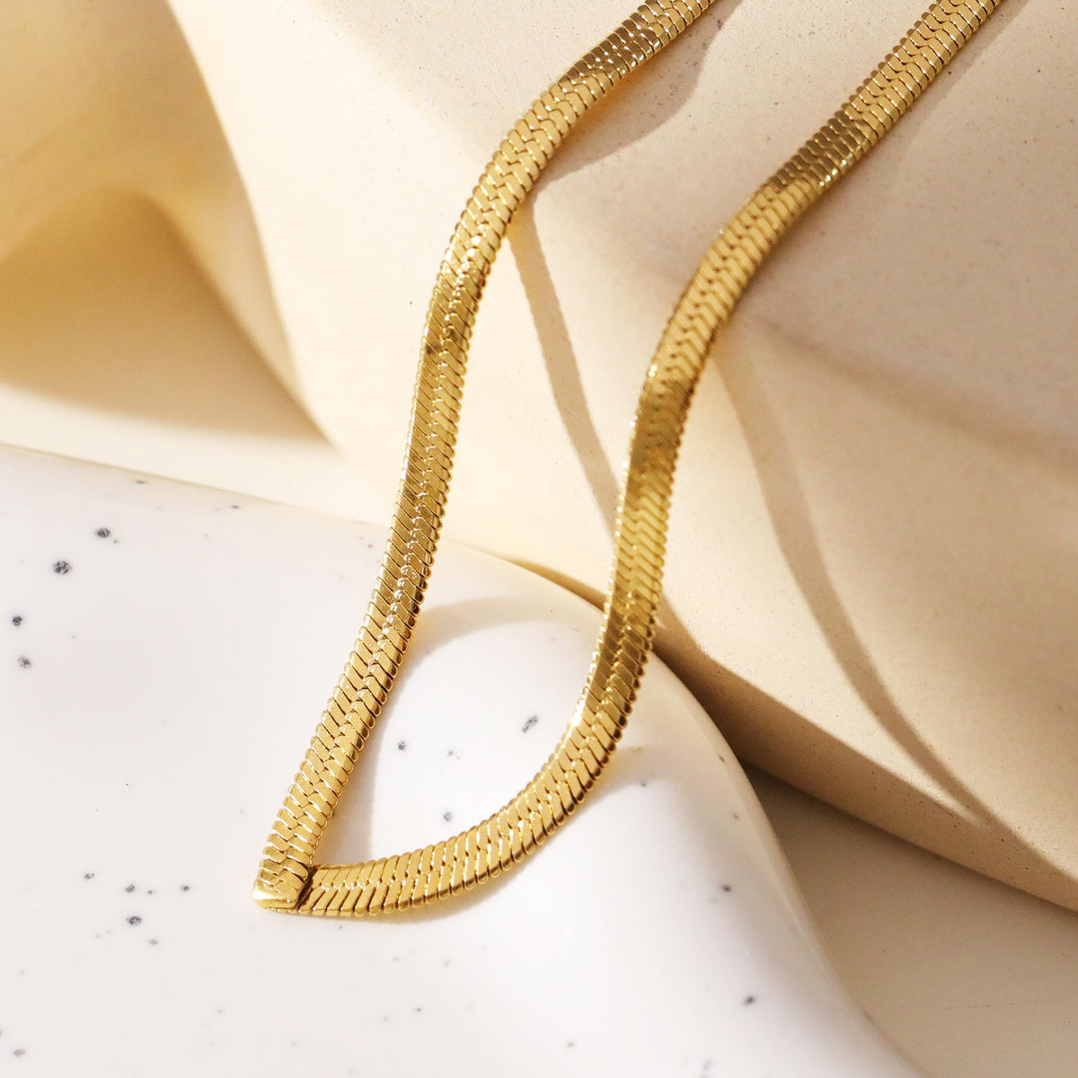 Collier GAURI asymétrique avec chaîne dorée texturée peau de serpent